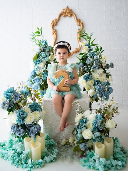 A beautiful portrait for her second birthday, surrounded by a sea of blue and white flowers.