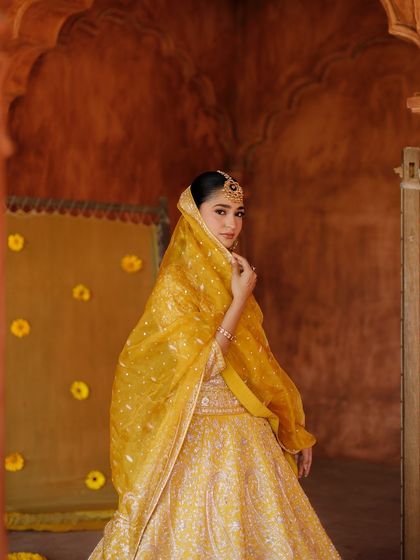 The sheer dupatta creates a soft, ethereal effect. The makeup is subtle yet defining, perfect for this traditional look.