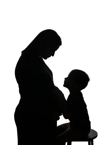 Carrying a piece of the moon and stars with me. A beautiful silhouette of a mother and her older child sharing a quiet moment with the baby bump.