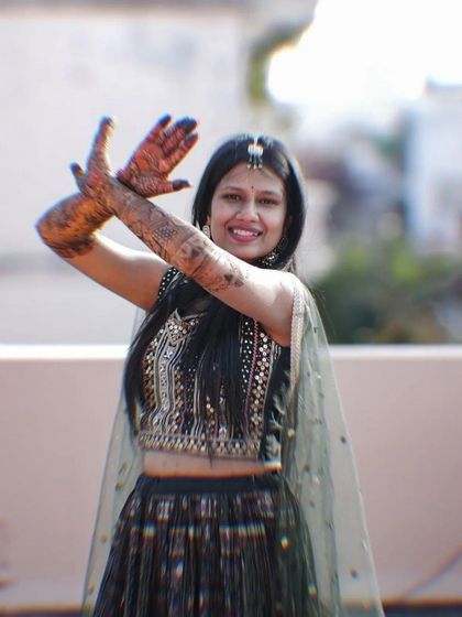 A joyful bride dancing and showing off her intricate bridal henna.