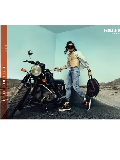 A 'High on Life' campaign image for Killer Jeans with a road trip theme. The styling is rugged and free-spirited, with an open shirt and worn-in denim, perfectly capturing the essence of adventure on the open road.