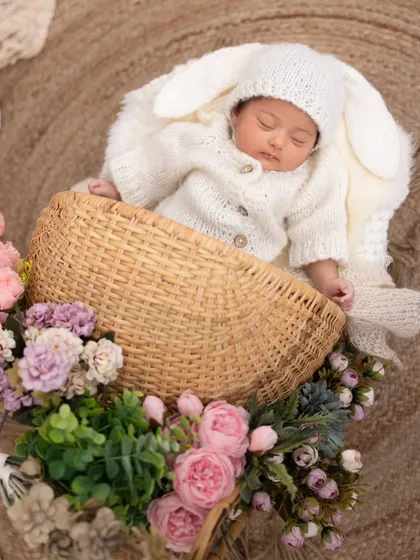 Our little bunny is fast asleep in a basket of flowers. The adorable knit outfit with long bunny ears makes this a perfect choice for a spring or Easter-themed newborn session.