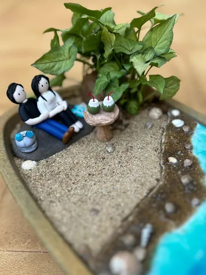 A perfect place to spend a cozy evening. This beach-themed miniature garden was a custom order for a couple, complete with figurines that look like them.