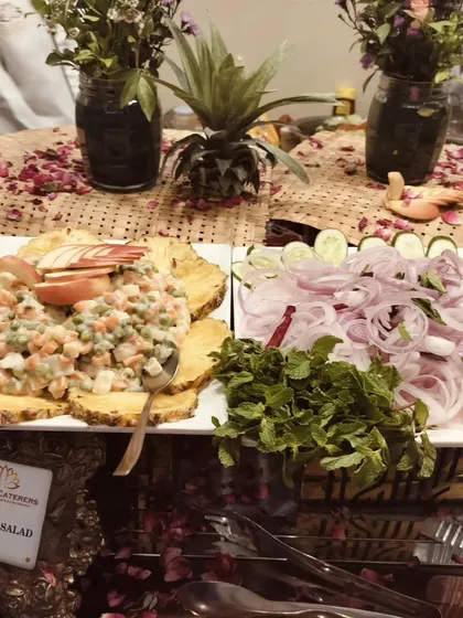 My classic Russian salad served on a bed of carved pineapple, alongside a platter of fresh sliced onions and cucumbers.