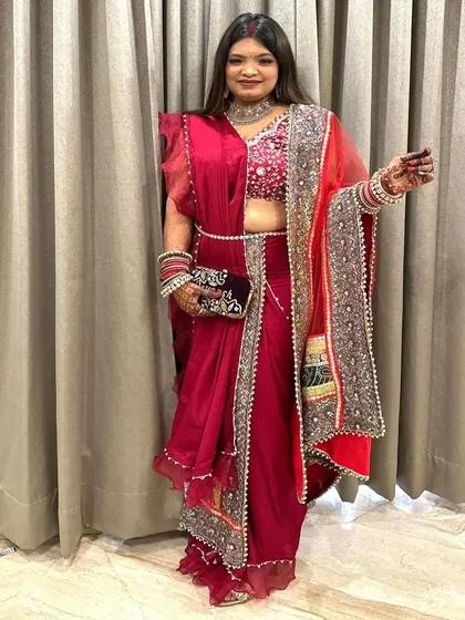 A stunning Karwa Chauth look. Her hair is styled with soft, open waves that complement the heavily embellished saree and create a royal look.
