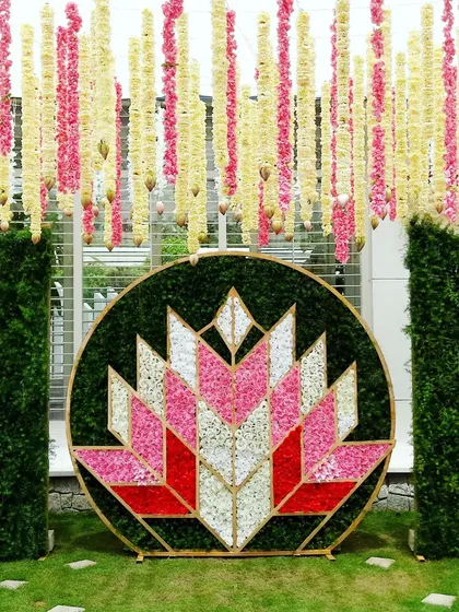 A modern naming ceremony backdrop with a geometric lotus design made of flower petals.