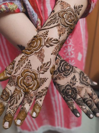 This design combines two different rose techniques. One hand features bold, filled-in roses, while the other showcases shaded roses, demonstrating the versatility of floral mehendi.