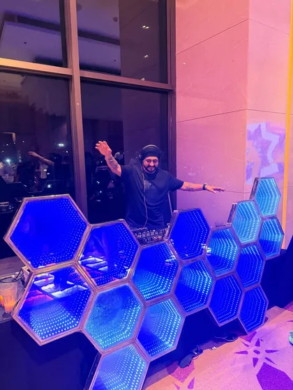 A different angle of the hexagonal DJ booth. The deep blue lighting creates a cool and energetic atmosphere.