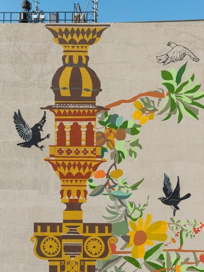 The upper portion of the hospital facade mural, where the architectural 'stambh' reaches towards the sky. The artwork is a heartfelt offering to the city, rooted in the past yet reaching for a harmonious future.