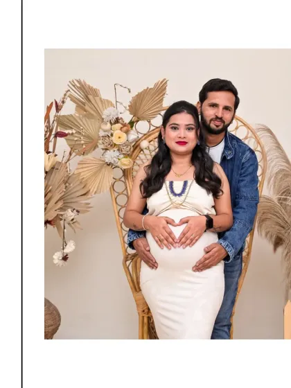 A beautiful couple's portrait featuring our wicker peacock chair. The mom-to-be forms a heart with her hands on her belly, a gesture of pure love, while her partner stands supportively behind her.