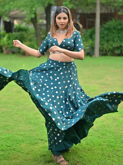 A fun, twirling shot in a polka-dotted lehenga. The makeup is playful yet polished, with a soft pink eyeshadow and a glowing base that looks great outdoors.