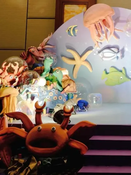 This stage setup for an underwater party is filled with a variety of sea creatures, creating a busy and vibrant ocean floor scene.