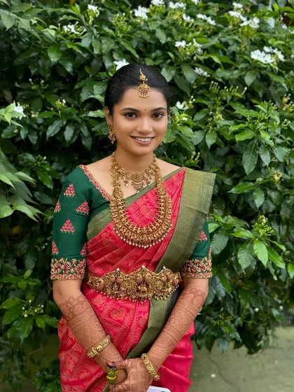 My beautiful bride Ragavi looking serene and elegant for her Muhurtham. Her subtle makeup look enhances her natural features, pairing beautifully with her pink and green Kanjeevaram saree and antique temple jewellery.