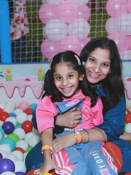 A mother and daughter sharing a happy moment in the ball pit at a birthday party. Capturing these loving relationships is at the heart of what I do.