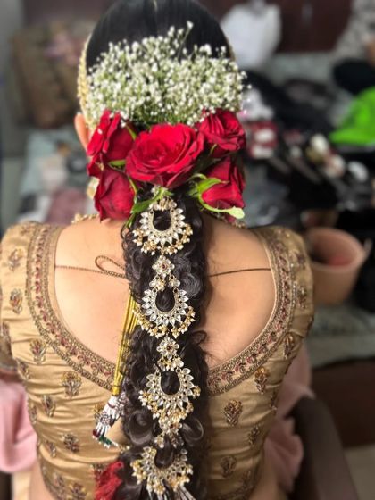 A full view of the traditional bridal braid, adorned with fresh flowers and heavy jewellery. This style is perfect for a South Indian wedding.