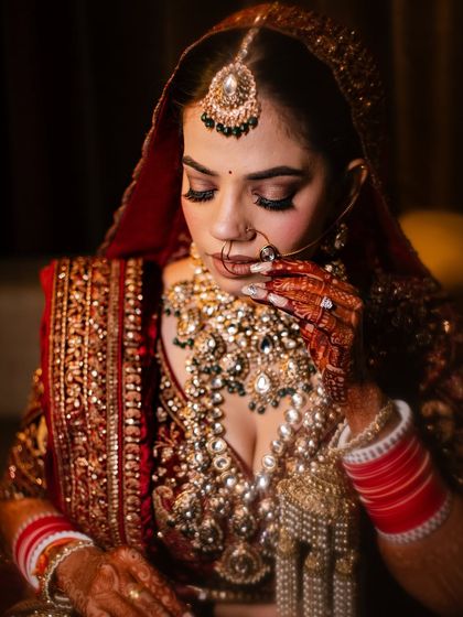 A close-up of Ashima's stunning bridal makeup. The focus is on the eyes, with long lashes and a soft, shimmery lid.