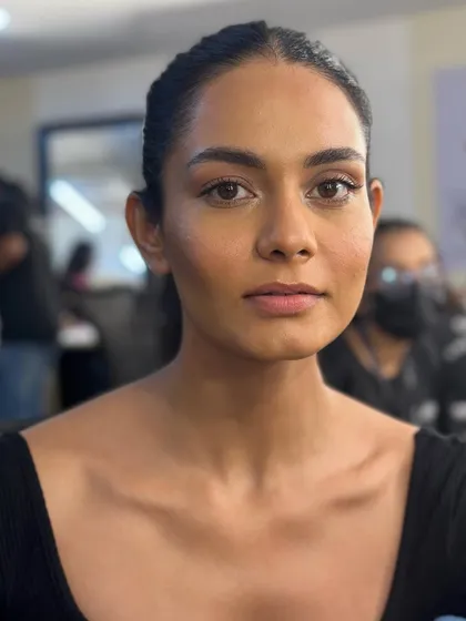 A straight-on, unfiltered view of the runway makeup. The look is all about subtle definition, groomed brows, and a skin-like finish that looks both natural and polished.