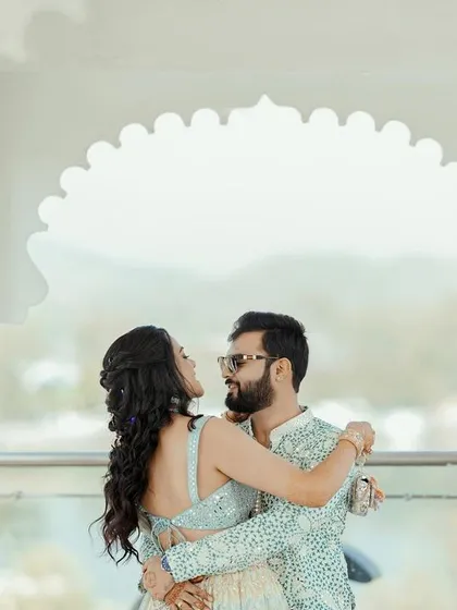 An intimate dance against the backdrop of Udaipur's beautiful landscape. The white marble architecture adds a touch of elegance and royalty to the couple's portrait.