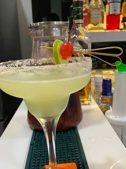 A classic Margarita with a perfectly salted rim and a lime and cherry garnish. We use fresh lime juice and premium tequila to create authentic and refreshing cocktails for your guests.