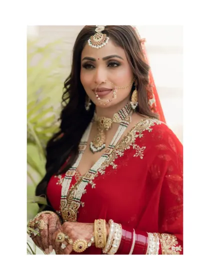 A classic, beautiful close-up of the bride, highlighting her stunning features, traditional jewelry, and the vibrant red of her outfit.