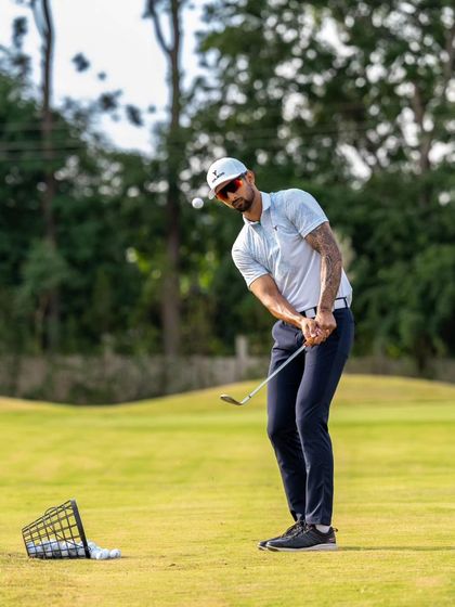 A golfer practices their short game on our pristine chipping green. We emphasize consistent practice to build confidence in this crucial area of golf.
