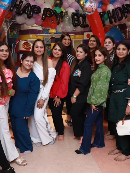 A group of friends gathers for a photo at a Cars-themed birthday party. It's a great place for parents to socialize too.