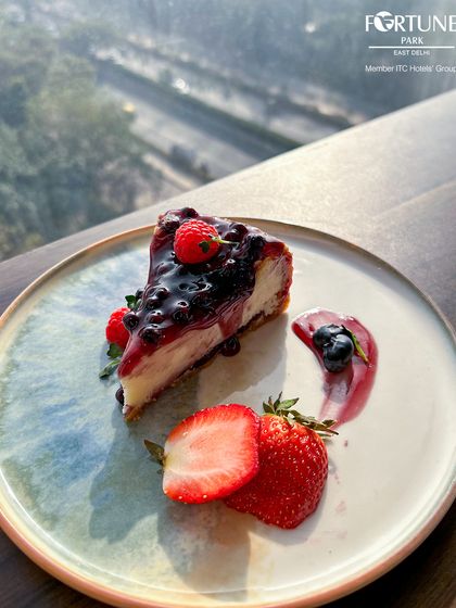 Our berry cheesecake, beautifully plated with fresh fruit and a delicate sauce, enjoyed with a view.