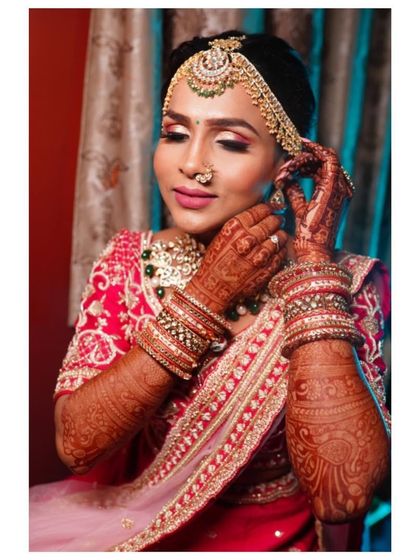 A smile and dark-stained henna are a bride's most beautiful makeup. A close-up of the bride getting ready, her intricate mehendi on full display.