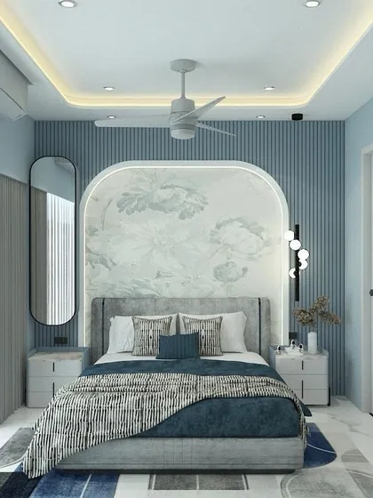 Soft hues create soft vibes. This bedroom uses a cool blue color palette with a fluted wall panel behind the bed and a custom arched headboard with delicate wallpaper to create a calming and dreamy space.
