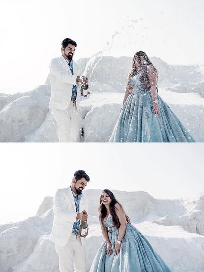A fun and candid moment from a pre-wedding shoot. The couple celebrates with champagne, and her beautiful blue ball gown adds a touch of fairytale magic to the happy occasion.