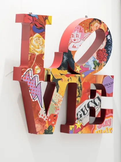 Another angle of the "Love Unleashed" sculpture, showing its three-dimensional form and the intricate details of the pop art collage within.
