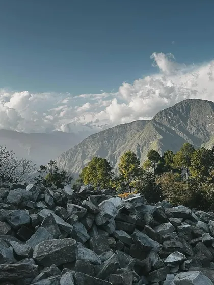 A pile of stones waits to be chiseled and placed, with the majestic mountains as a backdrop. This image speaks to the fundamental elements of our work: natural materials and an epic landscape.