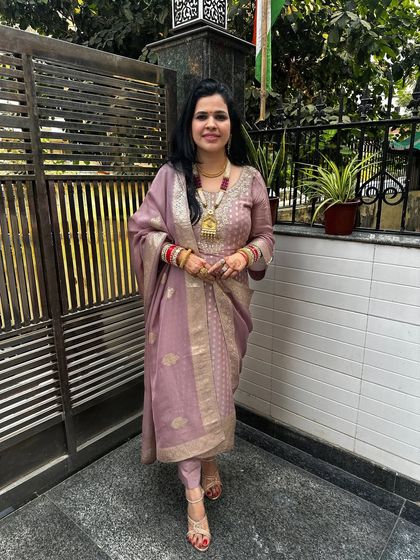 This mauve suit, designed for Karwa Chauth, features a lovely fabric with gold motifs. The custom design ensures a perfect fit and a unique look for the special day.