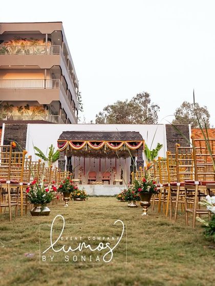 A view of the temple-style mandap from the aisle, framed by floral arrangements, creating a majestic path for the ceremony.