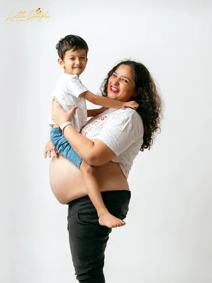 A joyful lift! This shot captures the fun and loving relationship between mother and son as they celebrate the coming arrival.