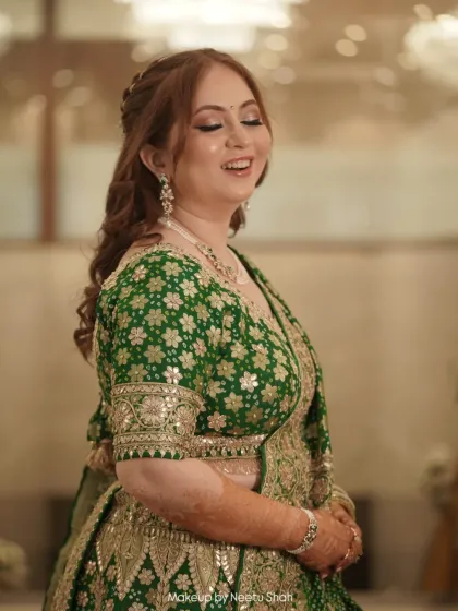 The picture of happiness. This bride's engagement look in a vibrant green lehenga is all about glowing skin and joyful energy. The soft, romantic makeup lets her smile be the centerpiece.