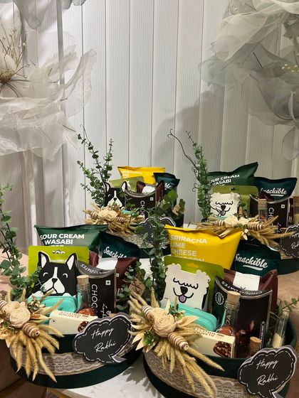 A snack-lover's dream hamper for Rakhi. These round green baskets are overflowing with a variety of savory treats.