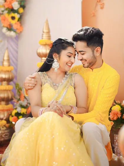 A tender embrace amidst the festive Haldi decor. This shot balances the vibrant energy of the event with the quiet intimacy of the couple's bond.