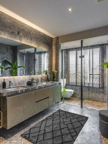 We infused this sprawling master bath in a Mumbai residence with natural light and tropical plants to create a natural retreat. The design choice of textured stone walls and a large, backlit mirror enhances the feeling of being in a private, serene oasis.