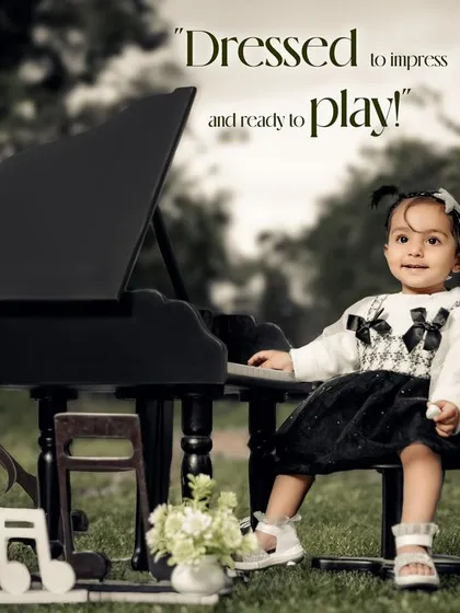 Dressed to impress and ready to play! A stylishly dressed girl with pigtails smiles at her mini piano in the park.
