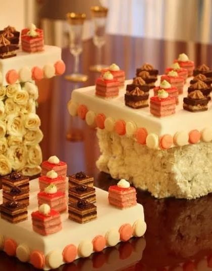 An architectural display of petit fours and macarons. This stunning presentation transforms dessert into a work of art, perfect for high-fashion and luxury events.