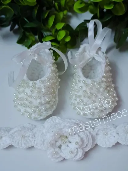This elegant baptism set includes my classic pearl-studded booties and a matching headband with a large, multi-layered flower, also detailed with pearls.