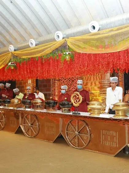 My team excels at creating beautiful, themed buffet counters. This setup, with its intricate chariot wheel designs and warm lighting, shows how I blend delicious food with stunning presentation for a royal wedding feel.