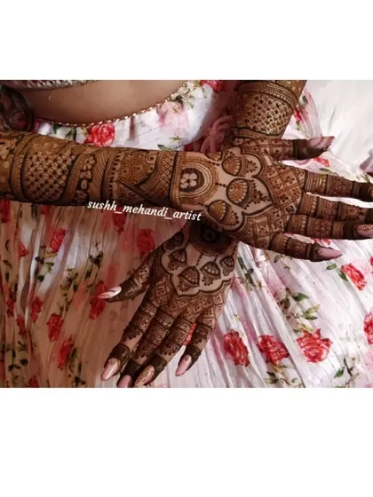 A lovely shot of a bride's hands, crossed to show the full design. This pattern features ring and initial motifs for a personal touch.