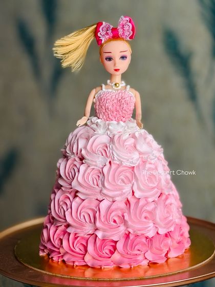 A classic doll cake design where the cake itself becomes a beautiful, flowing gown. This one features an ombre pink rosette design made with buttercream.