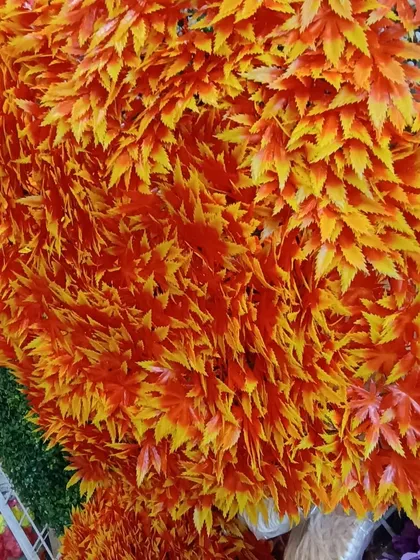 Bright and vibrant artificial maple leaf garlands in shades of orange and yellow. These are perfect for adding a pop of autumnal color to your festival decorations.