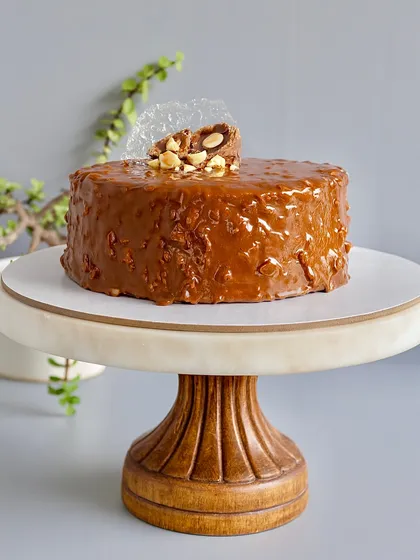 This is my signature Almond Rocher Cake, and it's a bestseller for a reason. It has layers of rich chocolate sponge and Nutella ganache, all wrapped in a crunchy almond chocolate glaze. It’s pure indulgence with a satisfying crunch in every bite.