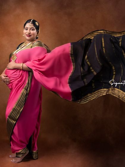 The flowing saree in this shot creates a dynamic and powerful image, full of movement and color.