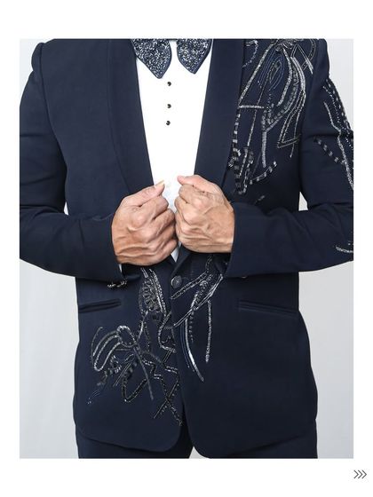 A full torso shot of the embellished navy tuxedo. The detailed beadwork flows down the lapels, creating a visually stunning effect that's perfect for photos.