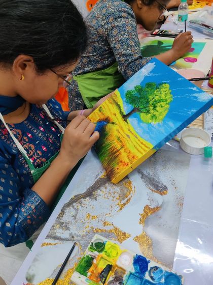 An AIIMS doctor fully engaged in painting a landscape on canvas. Our workshops provide all the guidance and materials needed for a fulfilling experience.